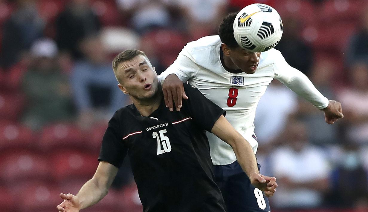 Gelandang Inggris, Jude Bellingham (kanan) berduel udara dengan striker Austria, Sasa Kaladzic dalam laga uji coba menjelang berlangsungnya Euro 2020 di Riverside Stadium, Middlesbrough, Rabu (2/6/2021). Inggris menang 1-0 atas Austria. (AP/Scott Heppell/Pool)