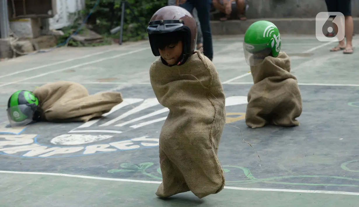 Sejumlah peserta beradu cepat dalam lomba balap karung helm di Kelurahan Benda Baru, Pamulang, Tangerang Selatan, Senin (17/8/2020). Lomba balap karung helm tersebut diselenggarakan untuk memeriahkan peringatan HUT ke-75 Kemerdekaan RI. (merdeka.com/Dwi Narwoko)