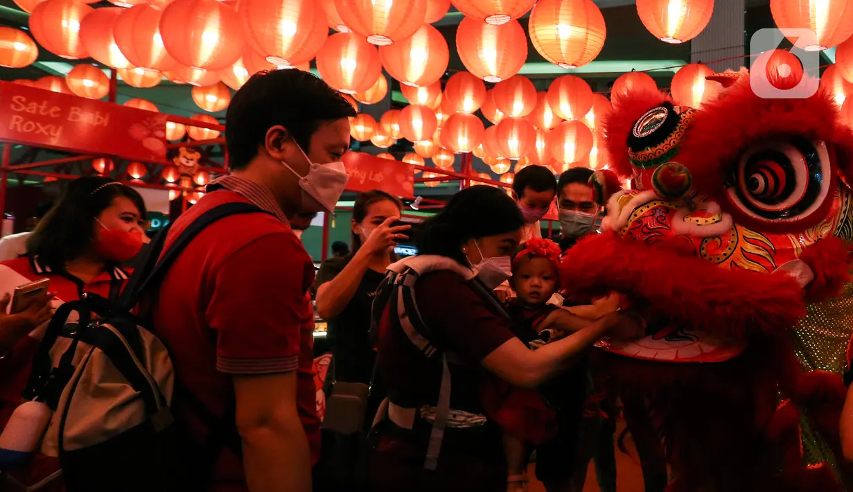 Pengunjung memberi angpao pada Barongsai yang beraksi di mal kawasan Jakarta, Minggu (30/1/2022). Dalam rangka menyambut Tahun Baru Imlek, Mal di Jakarta menghadirkan atraksi barongsai yang untuk menghibur pengunjung dan menarik daya beli masyarakat. (Liputan6.com/Johan Tallo)