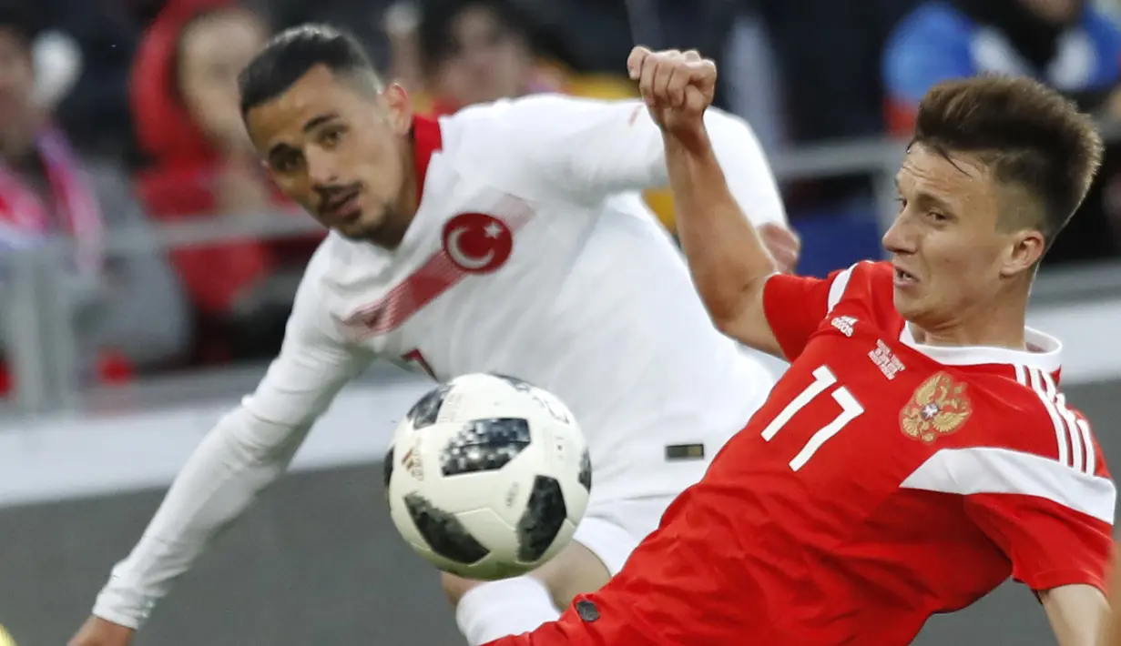 Pemain Turki, Serdar Gurler (kiri) berusaha menutup pergerakan pemain Rusia, Aleksandr Golovin pada laga uji coba di VEB Arena stadium, Moskow, Rusia, (5/6/2018). Rusia bermain imbang 1-1. (AP/Pavel Golovkin)