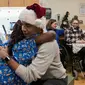 Mantan Presiden AS, Barack Obama memeluk seorang pasien anak di Children's National Medical Center , Washington, Rabu (19/12). Kedatangan Obama yang menyerupai sinterklas itu untuk membagikan hadiah natal kepada anak-anak di sana. (Chuck Kennedy / AFP)