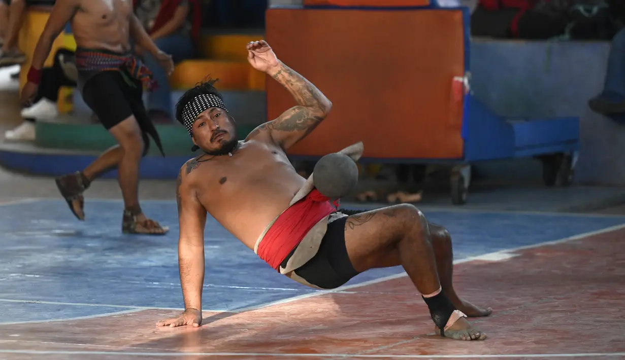 Pria pribumi bermain dalam final turnamen bola Maya di San Juan La Laguna, Solola, Guatemala, pada 18 September 2021. Permainan bola maya ini merupakan permainan bola yang dipukul menggunakan bagian pinggul. (Johan ORDONEZ/AFP)