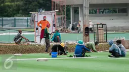 Pekerja menyelesaikan renovasi lapangan latihan timnas Indonesia di Kompleks Gelora Bung Karno, Senayan, Jakarta, Rabu (10/5). Pemerintah melakukan renovasi total kawasan Gelora Bung Karno guna menyambut Asian Games 2018. (Liputan6.com/Gempur M Surya)