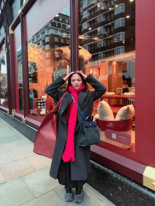Ia padukan long sleeve dan syal wol merah dengan long coat abu-abu dan rok hitam [@amelcarla]