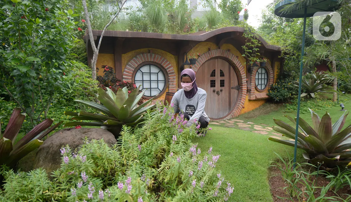 Pekerja merawat tanaman di taman tematik bernuansa rumah hobbit di kawasan hunian vertikal di Serpong, Tangerang, Banten, Kamis (3/12/2020). aman tematik tersebut bertujuan untuk mendukung relasi sosial antar warga serta menciptakan hunian sehat di tengah pandemi COVID-19. (merdeka.com/Dwi Narwoko)