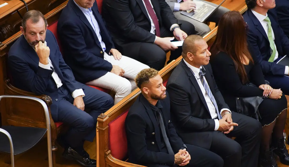 Mantan pemain Barcelona, Neymar (kiri-depan) yang sekarang bermain untuk Paris Saint-Germain melambaikan tangan saat tiba di ruang pengadilan di Barcelona, Spanyol, Senin (17/10/2022). Neymar kembali ke Spanyol untuk menghadiri persidangan atas tuduhan penipuan terkait transfer dari Santos ke Barcelona pada 2013 lalu. (AP Photo/Joan Mateu Parra)