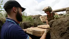 Aleksey Kachko, salah satu pemilik kedai Pizza Veterano di Mariupol menyerahkan sekotak pizza kepada seorang tentara Ukraina yang bertugas di garis depan menghadapi separatis pro-Rusia di wilayah timur negeri itu, 19 Juli 2018. (AFP/Aleksey FILIPPOV)