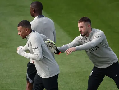 Penyerang Paris Saint-Germain Kylian Mbappe dan kiper Arnau Tenas (kanan) menghadiri sesi Latihan menjelang leg kedua semifinal Liga Champions 2023/2024 di Campus PSG di Poissy, Senin (6/5/2024). (FRANCK FIFE / AFP)