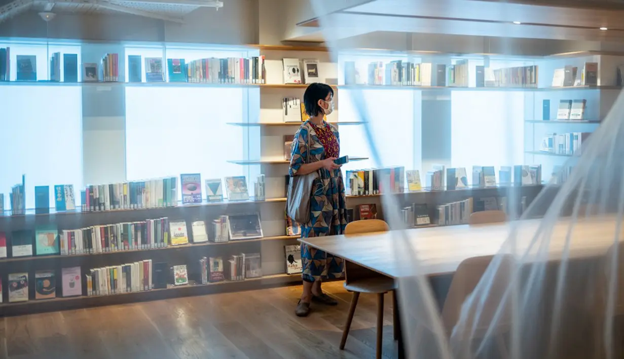 Seorang reporter berdiri dalam Rumah Sastra Internasional Waseda di Universitas Waseda, Tokyo, Jepang, 22 September 2021. Rumah Sastra Internasional Waseda yang juga dikenal sebagai Perpustakaan Haruki Murakami dirancang oleh arsitek Jepang, Kengo Kuma. (Philip FONG/AFP)