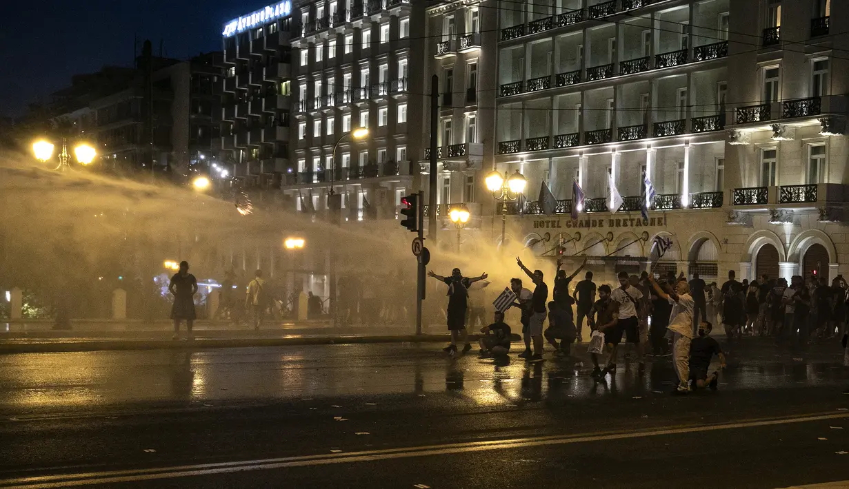Polisi Yunani menggunakan meriam air untuk membubarkan pengunjuk rasa anti-vaksin selama rapat umum di alun-alun Syntagma, Athena tengah (24/7/2021). Pengunjuk rasa menentang vaksinasi wajib bagi para pekerja, seperti staf tenaga kesehatan dan perawat. (AP Photo/Yorgos Karahalis)