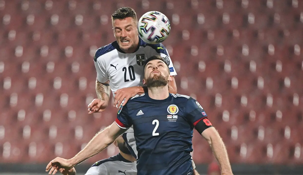 Bek Skotlandia, Stephen O'Donnell, berebut bola dengan gelandang Serbia, Sergej Milinkovic-Savic, pada babak playoff Piala Eropa 2020 di Red Star Stadium, Jumat (13/11/2020) dini hari WIB. Skotlandia menang 5-4 atas Serbia lewat adu penalti. (AFP/Andrej Isakovic)