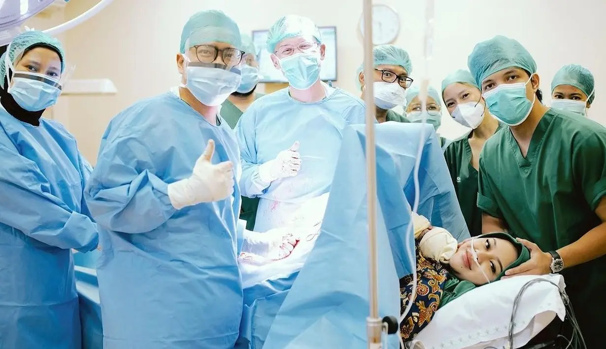 Saat foto dengan dokter dan tenaga medis lainnya di ruang persalinan, wajah Aurel tetap ditutupi