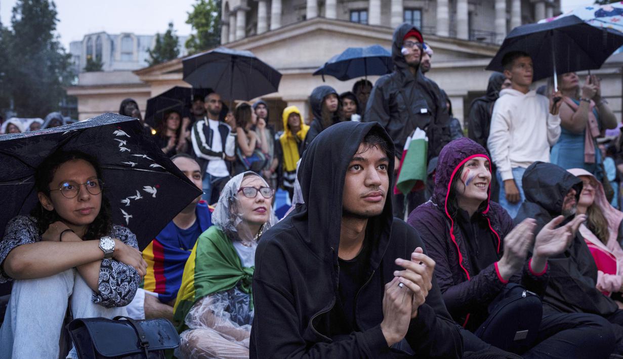 Penonton yang berjumlah sekitar 300.000 orang menyaksikan langsung dari tribun yang dibangun khusus di tepi sungai, sementara 200.000 lainnya menyaksikan dari balkon dan apartemen yang menghadap ke sungai. (AP Photo/Louise Delmotte)