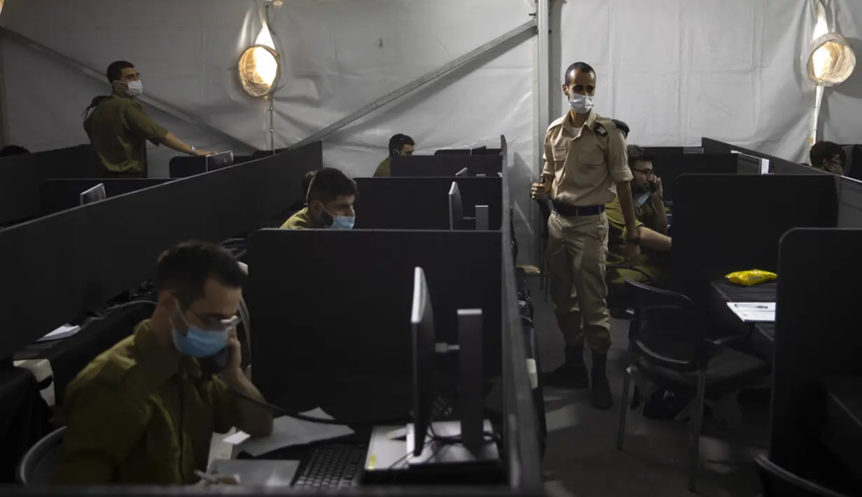 Tentara mewawancarai seseorang yang terinfeksi COVID-19 untuk mengidentifikasi dengan siapa orang tersebut telah berhubungan di Markas Home Front Command, Ramle, Israel, 25 Agustus 2020. Israel mengerahkan tentara untuk membantu menghadapi pandemi COVID-19. (AP Photo/Sebastian Scheiner)