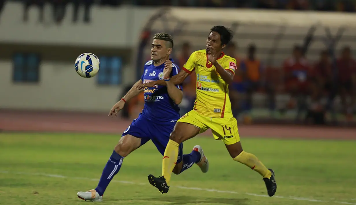 Penyerang Arema Cronus, Cristian Gonzales berusaha melewati pemain Sriwijaya FC, Fathul Rahman pada babak semi final Piala Presiden di Stadion Manahan, Solo, Minggu (11/10/2015). Sriwijaya berhasil lolos ke babak final. (Bola.com/Nicklas Hanoatubun)