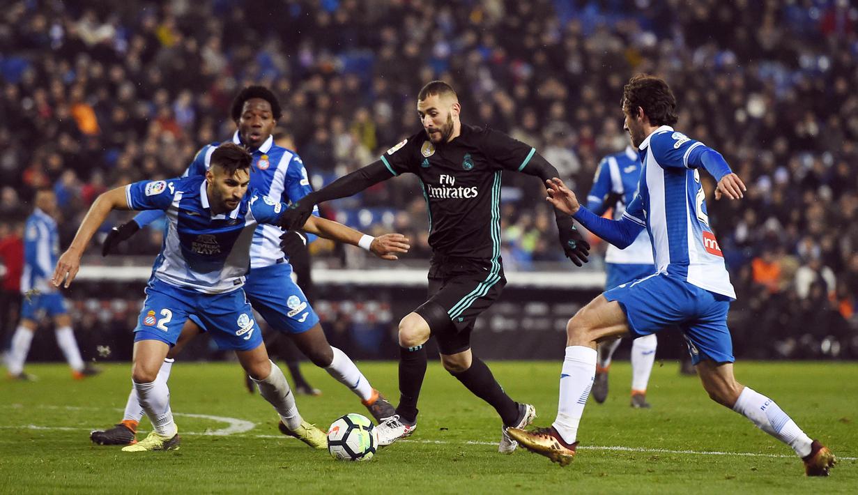 Striker Real Madrid, Karim Benzema, berusaha melewati pemain Espanyol pada laga La Liga di Stadion RCDE, Barcelona, Selasa (27/2/2018). Espanyol menang 1-0 atas Real Madrid. (AFP/Josep Lago)