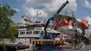 Salah satu bagian ekor pesawat AirAsia QZ8501 diangkat menggunakan Crane dibawa menuju gudang penyimpanan di Pelabuhan Panglima Utar, Kumai, Kalimantan Tengah, Senin (12/01/2015).  (Liputan6.com/Andrian M Tunay)