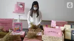 Pendiri Tomaple Gourmet Potato Donuts, Lala Ursula menyiapkan hampers untuk konsumen di salah satu outlet Tomaple di Jakarta, Sabtu (08/5/2021). Donat yang mampu berkreasi dengan pasar milenial dan didominasi warna pink mengusung tema #pinkboxhappines. (Liputan6.com/HO/Tomaple)