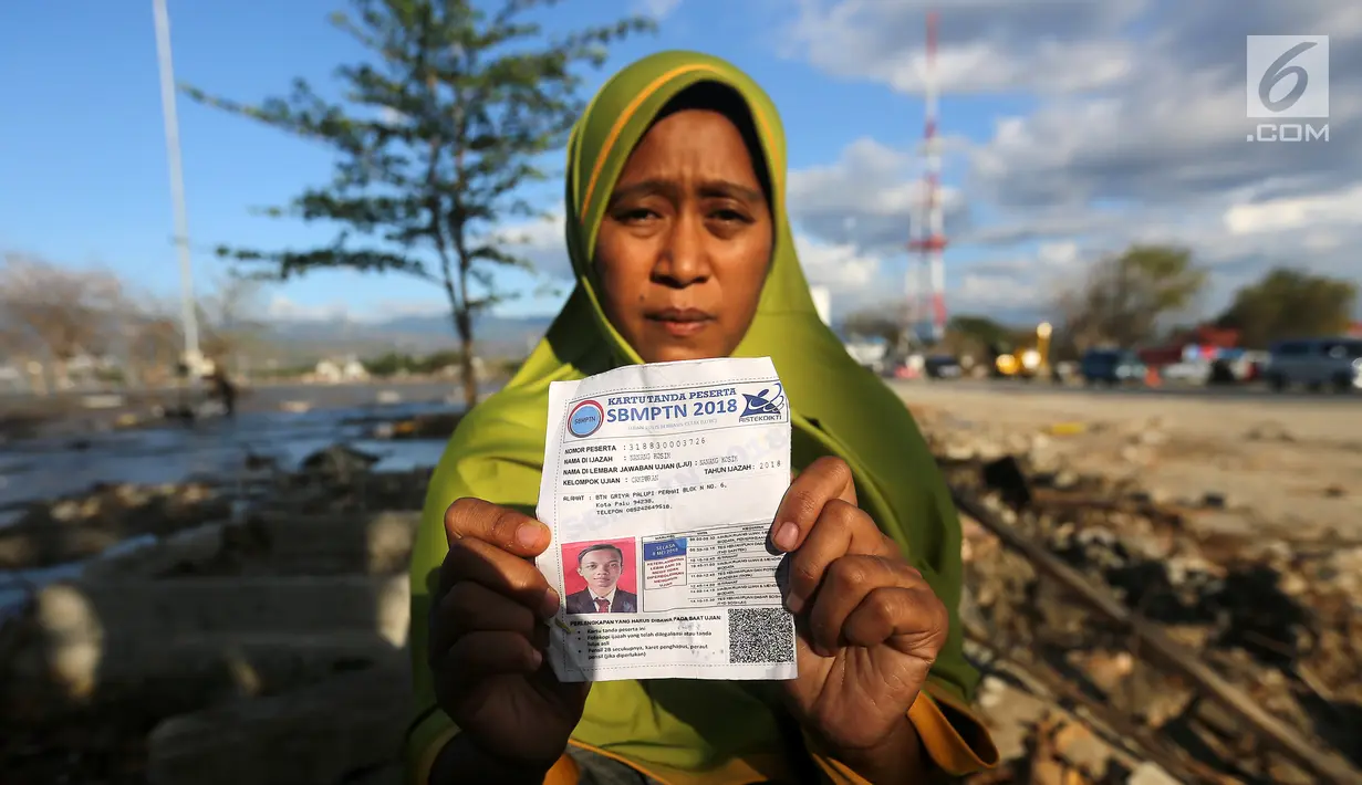Seorang ibu bernama Lita, menunjukkan foto anaknya, Nanang Kosim (20) yang belum ditemukan pascagempa dan tsunami Palu di Pantai Talise, Sulawesi Tengah, Senin (8/10). Nanang diduga masih tertimbun di dalam tanah saat tsunami. (Liputan6.com/Fery Pradolo)