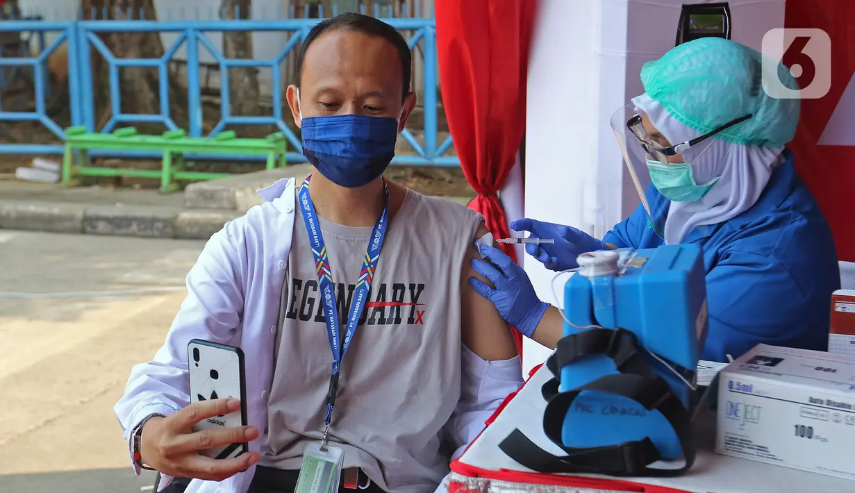 Pelaku transportasi saat menerima vaksinasi COVID-19 Ndi Terminal Kampung Rambutan, Jakarta, Kamis (10/6/2021). Vaksinasi massal ini untuk 1.000 orang yang terdiri dari para supir bus, kernet, pedagang usaha kecil dan mikro di Terminal Kampung Rambutan. (Liputan6.com/Herman Zakharia)