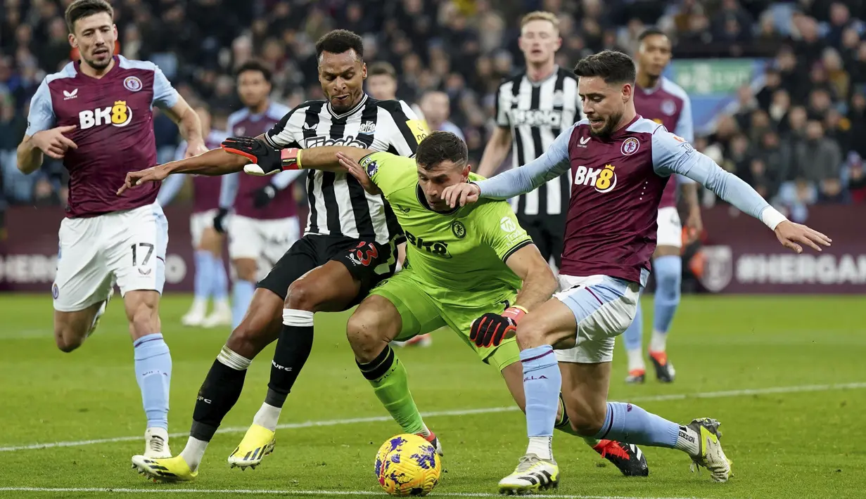 Kiper Aston Villa, Emiliano Martinez, berusaha merebut bola dari pemain Newcastle United, Jacob Murphy, pada laga Liga Inggris di Stadion Villa Park, Birmingham, Selasa (30/1/2024). (Jacob King/PA via AP)