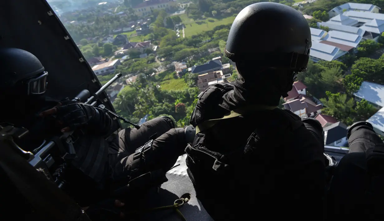 Prajurit TNI Batalyon Raider 112/Dharma Jaya melihat keluar dari helikopter ketika berpartisipasi pada latihan penanggulangan anti teror di Banda Aceh, Sabtu (11/5/2019). Latihan ini untuk meningkatkan kemampuan dalam melaksanakan tugas operasi yang bersifat khusus. (CHAIDEER MAHYUDDIN/AFP)