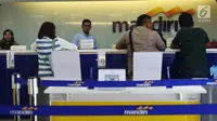 Nasabah melakukan transaksi di cabang Bank Mandiri Pertamina UPMS III, Jakarta, Rabu (28/6). Bank Mandiri memberikan layanan perbankan terbatas kepada nasabah secara bergantian pada musim liburan Idul Fitri 26-30 Juni 2017. (Liputan6.com/Angga Yuniar)