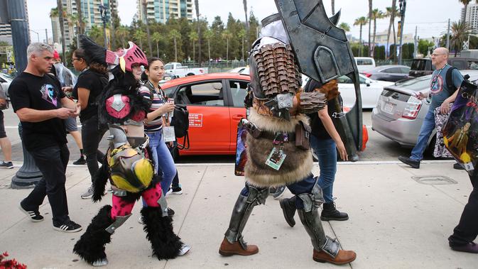 Para cosplay berjalan di luar Comic-Con, San Diego, California, Amerika Serikat, Jumat (20/7). (Mario Tama/Getty Images/AFP)
