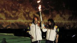 Legenda bulutangkis Indonesia, Susi Susanti dan mantan atlet tenis Yustedjo Tarik, saat prosesi kirab obor di Candi Prambanan, Rabu (18/7/2018). Api obor Asian Games tersebut akan dibawa mengelilingi 18 provinsi. (Bola.com/M Iqbal Ichsan)