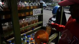 Pedagang melayani pembelian bensin eceran jenis premium di kawasan Petamburan, Jakarta, Senin (2/3/2015). Pemerintah kembali menaikkan harga BBM jenis Premium sebesar Rp 200 per liter per 1 Maret 2015 pukul 00.00 WIB. (Liputan6.com/Johan Tallo)
