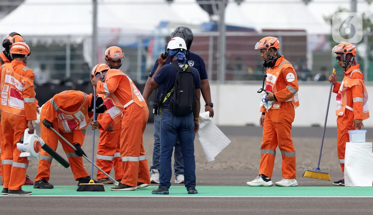 Marshal membersihkan lintasan jelang kualifikasi MotoGP di Pertamina Mandalika International Street Sirkuit, Lombok, Sabtu (19/3/2022). Startline Marshals memastikan bahwa semua pembalap berada dengan benar di grid start. (Liputan6.com/Helmi Fithriansyah)