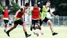 Pemain Persikabo 1973, Andre Oktaviansyah (tengah) berebut bola dengan Sergey Pushnyakov saat sesi latihan perdana di Lapangan Samudra, Badung, Bali, Minggu (03/01/2022). Latihan tersebut menjadi bagian dari persiapan menghadapi Arema FC  pada 5 januari mendatang. (Bola.com/Nandang Permana)