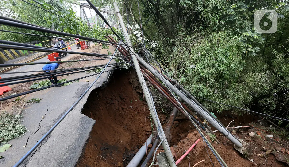 Kondisi longsor di kawasan Jembatan Darul Qur’an, Jalan KH. Tb. M. Falak, Kecamatan Bogor Barat, Kota Bogor, Jawa Barat, Rabu (12/10/2022). Longsor yang terjadi pada kemarin sore saat hujan deras menyebabkan jalan utama yang menghubungkan Jalan Semeru dengan Jalan Raya Loji-Gunung Batu kini hanya dapat dilalui sepeda motor. (merdeka.com/Arie Basuki)