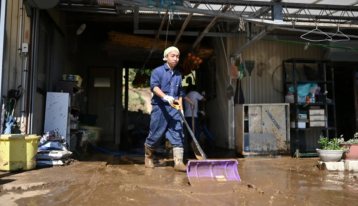 Penduduk membersihkan lumpur dari sebuah rumah setelah banjir surut di distrik Shibata, Prefektur Miyagi, Minggu (13/10/2019). Topan dahsyat Hagibis yang menerjang sejumlah wilayah di Jepang menyebabkan banjir di beberapa lokasi. (Photo by CHARLY TRIBALLEAU/ AFP)