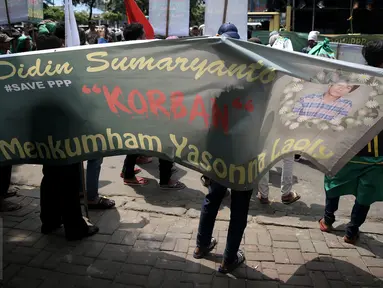 Pendukung PPP kubu Djan Faridz membawa spanduk bergambar kader PPP Didin Sumaryanto saat berdemosntrasi di depan Kemenkumham, Jakarta, Senin (25/4). Mereka mendesak agar MenkumHAM Yasona Laoly mundur dari jabatannya. (Liputan6.com/Faizal Fanani)