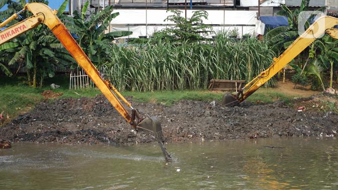 Alat berat mengeruk sampah bercampur lumpur di aliran Banjir Kanal Barat, Jakarta, Rabu (14/10/2020). Pengerukan serta pembersihan waduk, sungai, dan saluran air dari lumpur juga sampah untuk mencegah pendangkalan serta mengantisipasi banjir saat musim hujan. (Liputan6.com/Immanuel Antonius)