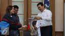 Gubernur DKI Jakarta Basuki Tjahaja Purnama menerima kaos film 3 Srikandi di Balai Kota, Jakarta, Selasa (19/7). Film 3 Srikandi melakukan promo sekaligus mengajak Ahok untuk nobar Film 3 Srikandi. (Liputan6.com/Herman Zakharia)