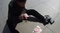 Seorang pria di Tiongkok yang menderita serangan jantung, dengan cerdik melemparkan uang ke jalan untuk menarik perhatian orang. (Doc: Nextshark)