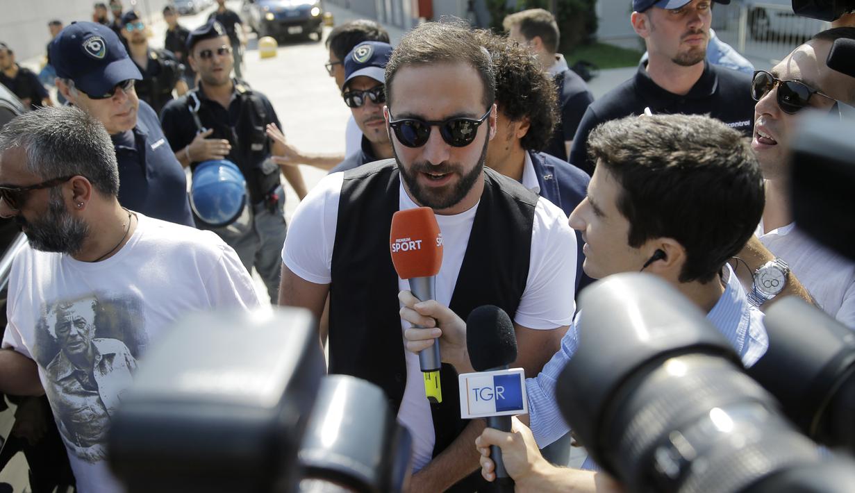 Sejumlah wartawan saat bertanya ke Gonzalo Higuain saat tiba di Juventus Medical Center, Italia (27/7). Mantan striker Napoli ini menjadi pemain kelima yang bergabung dengan Juve pada musim panas ini. (AFP PHOTO/MARCO BERTORELLO)
