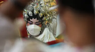 Seorang pemain opera Tiongkok yang mengenakan masker bersiap untuk tampil pada sebuah panggung di Bangkok, Rabu (6/10/2021). Sempat vakum, pertunjukan opera Tiongkok di Thailand kembali dihidupkan meski belakangan ini kasus harian Covid-19 kembali meningkat. (AP Photo/Sakchai Lalit)