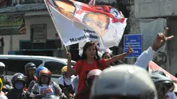 Seorang wanita simpatisan calon presiden pasangan nomor urut dua, Joko Widodo ikut berkonvoi dalam kampanye terbuka di kawasan Pasar Kota, Gresik, Jawa Timur, Minggu (29/6/14). (Liputan6.com/Herman Zakharia)