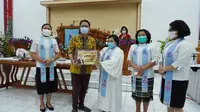 Jerry Sambuaga membagikan bingkisan Natal ke jemaat gereja di Sulut. (Istimewa)