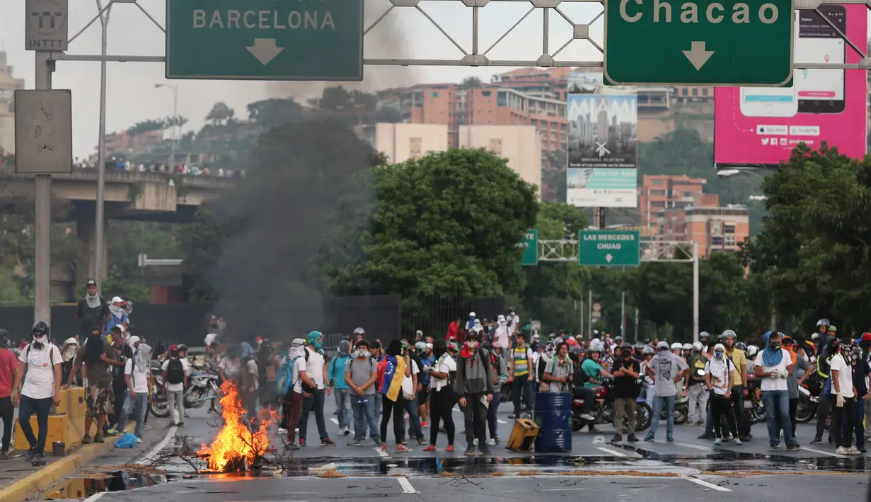 Demonstran dari oposisi memblokir sebuah jalan di Caracas, Venezuela (24/4). Protes anti pemerintah ini digelar untuk memblokir jalanan dalam upaya menghentikan aktivitas di Venezuela. (AP Photo/Fernando Llano)