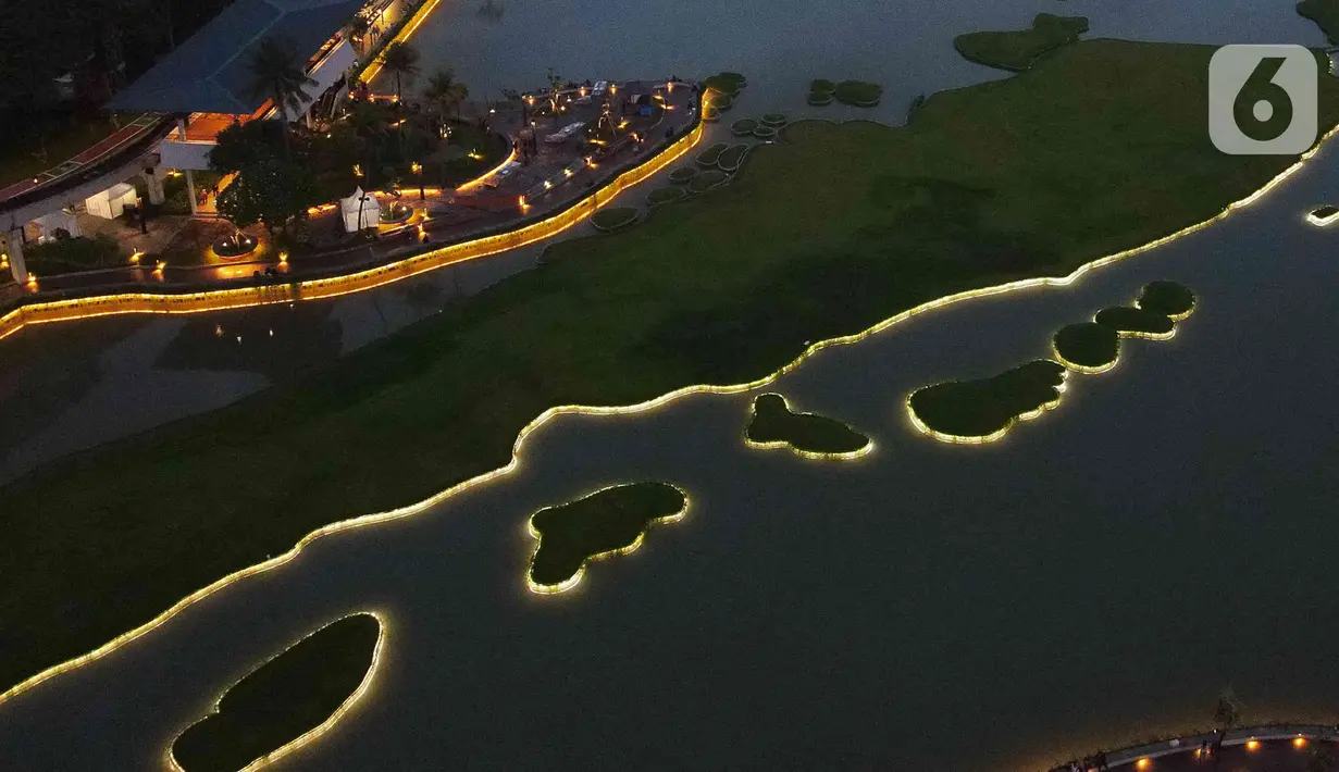 Foto udara memperlihatkan warna warni lampu Danau Archipelago di Taman Mini Indonesia Indah (TMII), Jakarta, Sabtu (31/12/2022). TMII menjadi salah satu lokasi acara puncak perayaan pergantian tahun di DKI Jakarta. (Liputan6.com/Herman Zakharia)