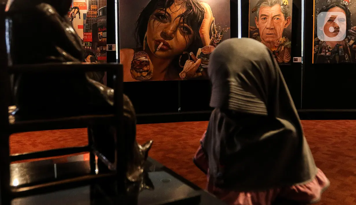 Pengunjung mengamati pameran seni rupa yang bertajuk 'Creative Freedom to Heal The Nation' di Perpustakaan Nasional, Jakarta, Kamis (15/10/2020). Pameran ini diharap dapat mendukung pemerintah dalam menanamkan kesadaran disiplin kepada masyarakat dalam menyikapi pandemi. (Liputan6.com/Johan Tallo)