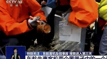 Pekerja darurat memegang perekam "kotak hitam" berwarna oranye yang ditemukan di lokasi kecelakaan pesawat Boeing 737-800 milik China Eastern Airlines di Kabupaten Tengxian di Daerah Otonomi Guangxi Zhuang, China selatan, Rabu (23/3/2022). (CCTV via AP Video)