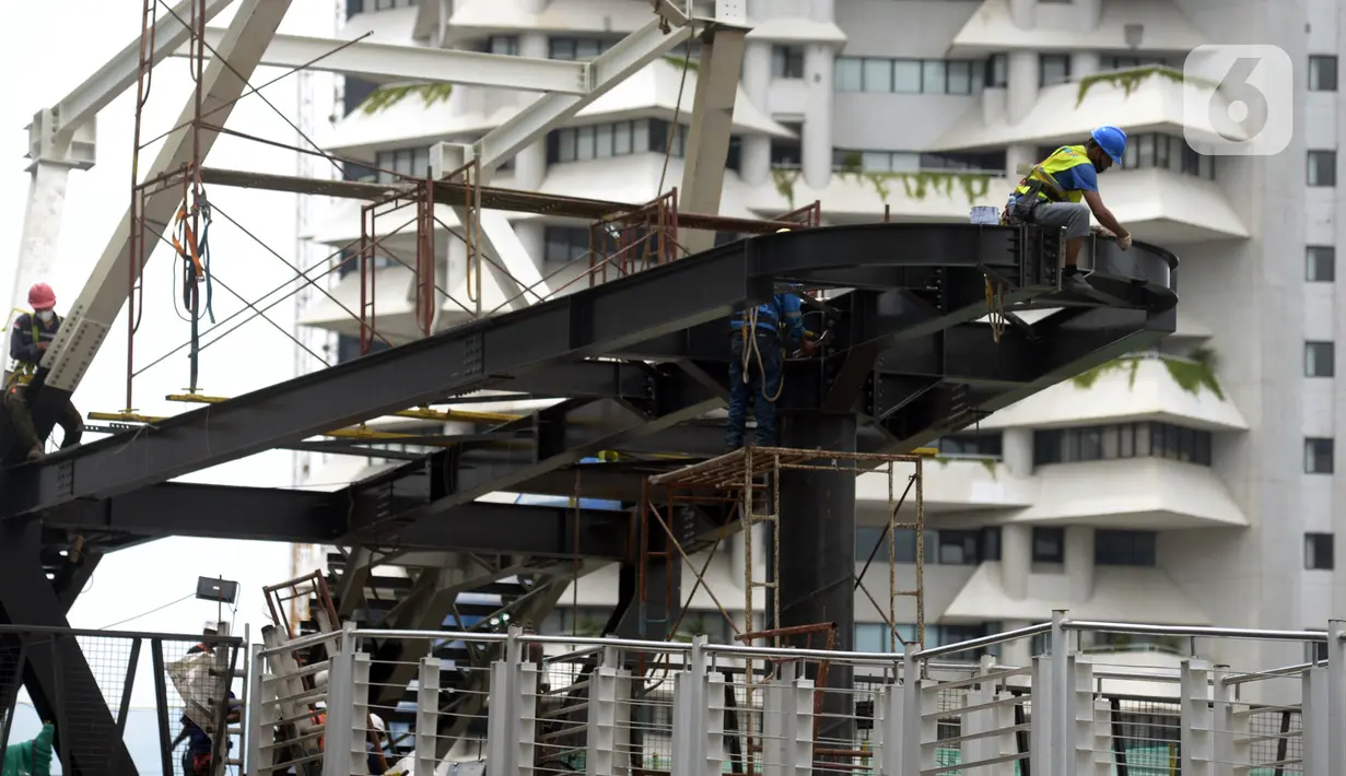 Pekerja menyelesaikan proyek Tugu Tenaga Kesehatan di Jembatan Penyeberangan Orang (JPO) Sudirman, Jakarta, Jumat (12/11/2021). Pembangunan Tugu Tenaga Kesehatan juga sebagai revitalisasi jembatan antara pejalan kaki, pesepeda, dan pengguna transportasi publik. (merdeka.com/Imam Buhori)