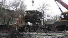 Seorang pria memuat truk militer, yang terbakar selama bentrokan ke peron di Almaty, Kazakhstan, Minggu (9/1/2022). Kementerian Kesehatan Kazakhstan mengatakan setidaknya 164 orang tewas dalam protes yang mengguncang negara itu selama seminggu terakhir. (Vladimir Tretyakov/NUR.KZ via AP)