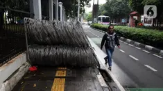 Pejalan kaki berjalan menghindari kawat berduri yang berada di trotoar Jalan Asia Afrika, Jakarta Pusat, Selasa (28/12/2021). Kawat berduri yang berada di trotoar tersebut sangat mengganggu para pejalan kaki yang melintas. (Liputan6.com/Johan Tallo)