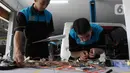 Pelajar SMK Negeri 26 Jakarta melakukan pengecekan instalasi part konversi mobil listrik di Bengkel Otomotif SMKN 26, Jakarta, Rabu (13/5/2023). (merdeka.com/Imam Buhori)